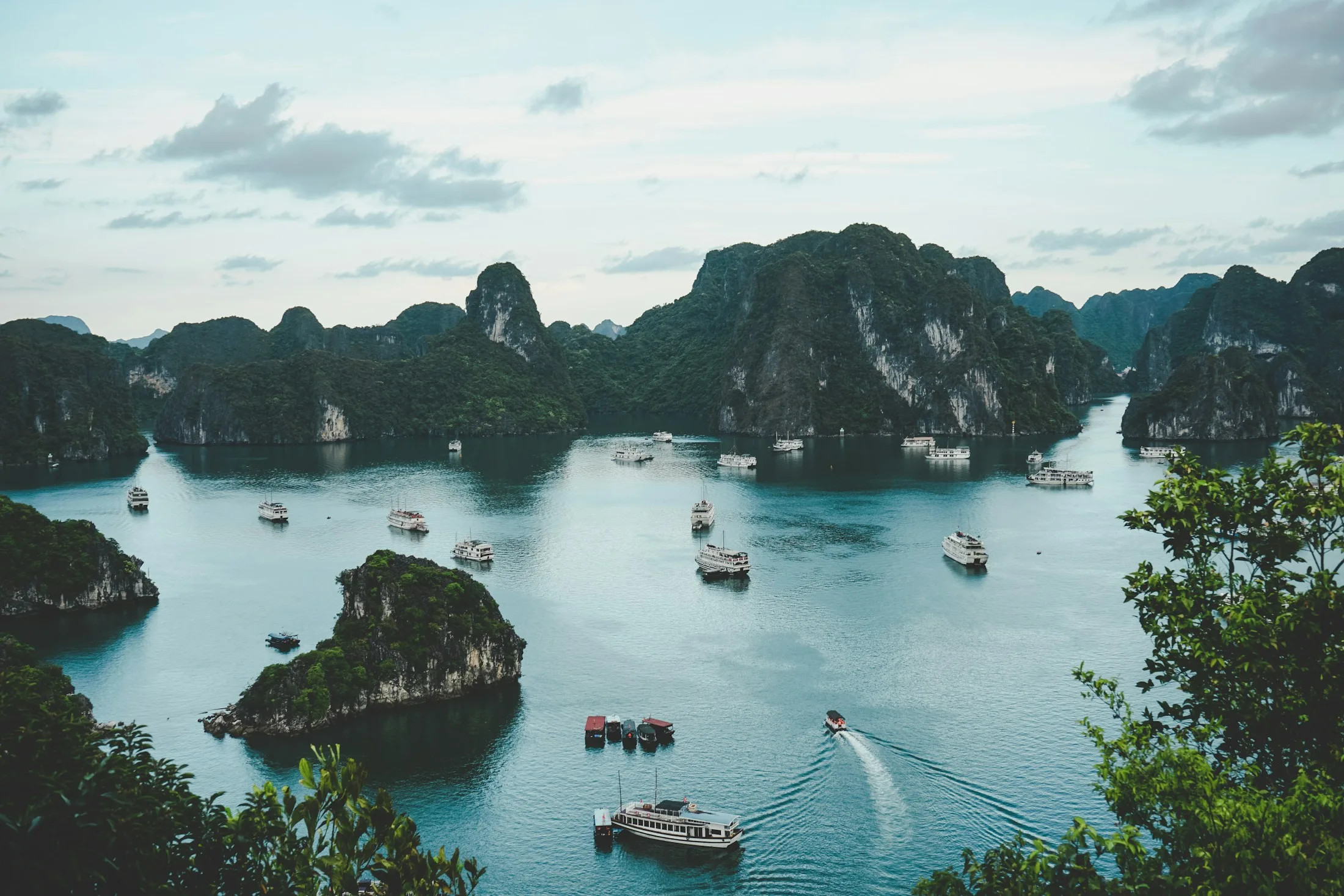 Limestone islands and boats in the emerald waters of Hạ Long Bay, Vietnam